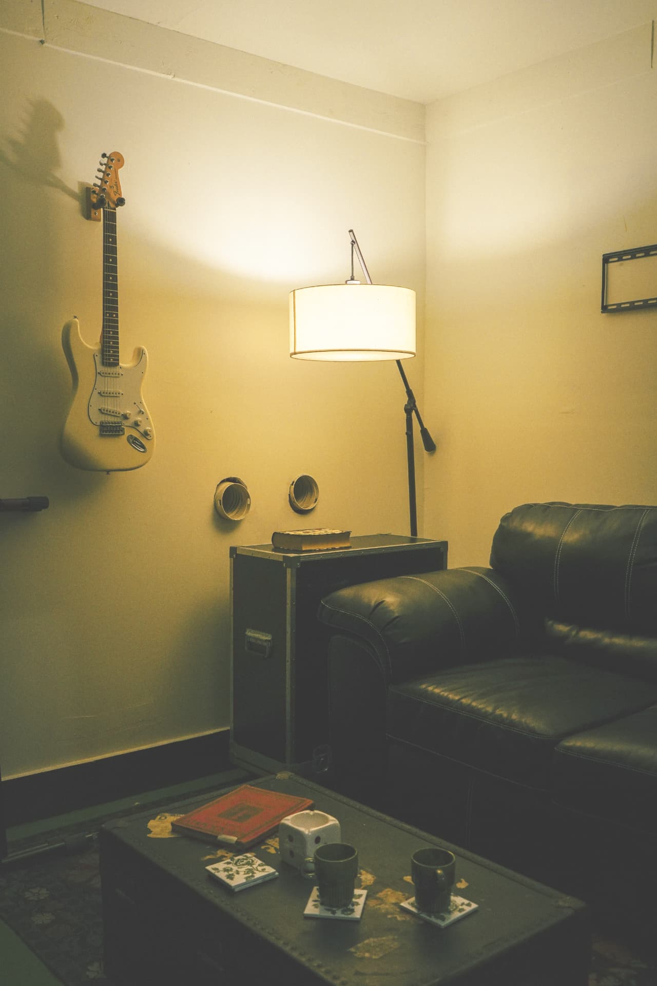 Lounge corner with a Fender Stratocaster and warm lamp light